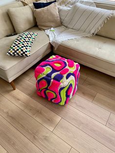 a living room filled with furniture and lots of pillows on top of the wooden floor