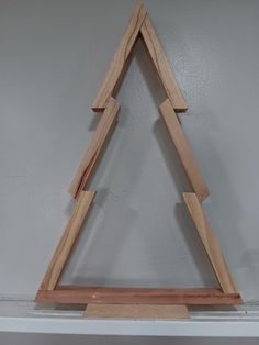 a wooden christmas tree on top of a shelf