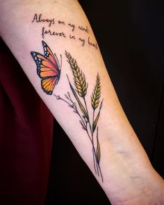 a woman's arm with an orange butterfly and some wheat stalks that say always on my mind, forever in my heart