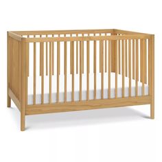 a small wooden crib with white sheets on the bottom and side rails, in front of a white background