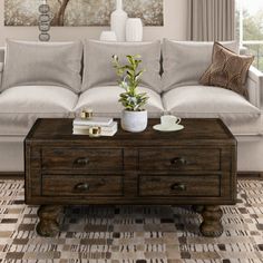 a living room with a couch, coffee table and two vases on the end tables