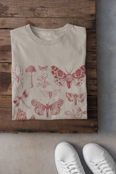 Thanks for stopping by! Moths and Mushrooms T-shirt Printed on a super soft, cotton tee Dispatched in 5 working days or sooner Unisex Free UK delivery Material: 100% ringspun cotton. Chest (to fit): S  34/36   M  38   L  40/42   XL  44/46   XXL  48/50 ECO-FRIENDLY Each garment is made to order, reducing extra material and energy that would be otherwise wasted We use DTG printing process which is easier on the environment than screen-printing Our ink is bright and also eco-friendly. Do not tumble Moths And Mushrooms, Fairycore Clothing, Tshirt Grunge, Clothing Cottagecore, Indie Clothing, Grunge Clothing, Cottagecore Shirt, Indie Outfits, Dtg Printing