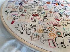 a close up of a cross stitch pattern on a white cloth with many different designs