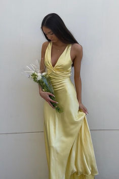 The v-neck satin party dress features a yellow color, soft material, and A-line silhouette. The front is twisted and the back crosses with a bow, creating an elegant look. This dress is full length and perfect for any occasion. SKU: 3894 Yellow color Soft satin material A-line silhouette Twist front with a v neck Cross cross with a bow in the back Full length Yellow Formal Dress, Simple Party Dress, Simple Prom Dress Long, Modest Evening Dress, Prom Evening Dresses, Matric Dance, Prom Dress Inspo, Floor Length Prom Dresses, Prom Dress Stores