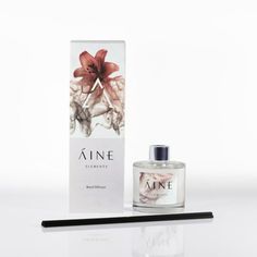 a bottle of perfume sitting next to a box on a table with a pen in front of it