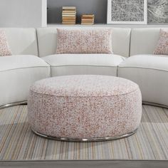 a living room with a white couch and round ottoman