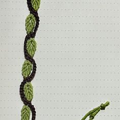 there is a crocheted plant with leaves on it