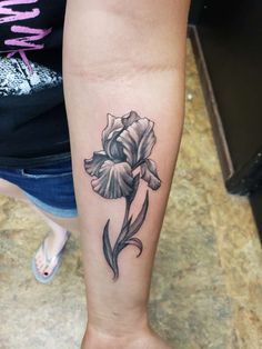 a black and white flower tattoo on the arm