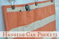 an orange and white striped fabric hanging on a hook with the words hanging car pockets