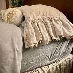 an unmade bed with two pillows and a blanket on it's headboard