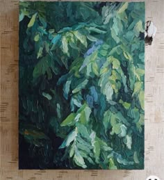 an oil painting of green leaves on a bamboo mat