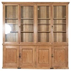 a wooden china cabinet with glass doors on the top and bottom shelves, in front of a white background