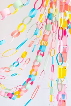 multicolored streamers hanging from the ceiling in front of a white wall and floor