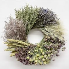 a wreath made out of dried lavenders and other flowers on a white background with space for text