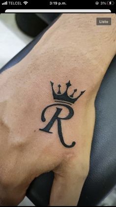 a man's hand with a tattoo on it and a letter r in the middle