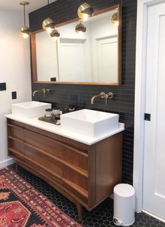 a bathroom with two sinks and a rug in front of the sink area is shown