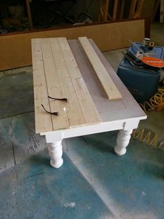 a table made out of pallets and some kind of wooden planks on the ground