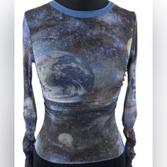 This Women's Urban Outfitters Blue Galaxy Mesh Top Is Perfect For A Night Out On The Town. It Is Made Of A Soft And Stretchy Mesh Fabric That Is Comfortable To Wear. The Top Features A Unique Galaxy Print With Stars, Planets, And Moons. It Has A Slim Fit And Is Cropped At The Waist. The Sleeves Are Long And Have A Ruffled Hem. The Top Is In Excellent Condition And Has Only Been Worn Once. Y2k Style Stretch Blue Tops, Trendy Fitted Blue Crop Top, Fitted Blue Y2k Tops, Fitted Blue Y2k Style Tops, Fitted Y2k Blue Tops, Blue Y2k Crop Top, Fitted Blue Crop Top With Graphic Print, Trendy Fitted Blue Tops, Urban Outfitters Blue Graphic Print Tops