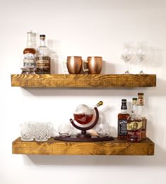 two wooden shelves filled with bottles and glasses