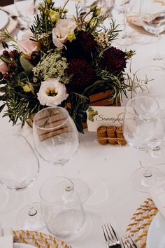 the table is set with wine glasses, place cards and silverware for guests to enjoy