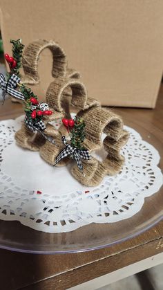 two burlocks are sitting on top of a doily with holly and bows