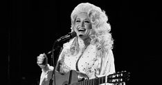 dolly monroe singing into a microphone and holding a guitar