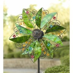 a decorative metal wind spinner with leaves and flowers on it