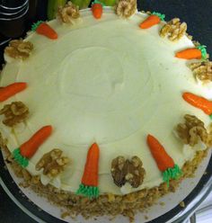 carrot cake with white frosting and walnuts on top