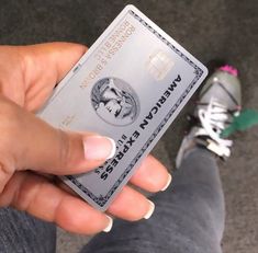 a person holding up a credit card in their hand