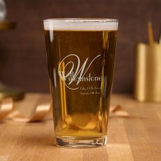 a beer glass sitting on top of a wooden table