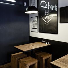 two wooden tables sitting next to each other in a room with posters on the wall