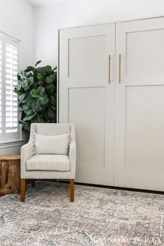 a white chair sitting in front of a wooden table on top of a carpeted floor