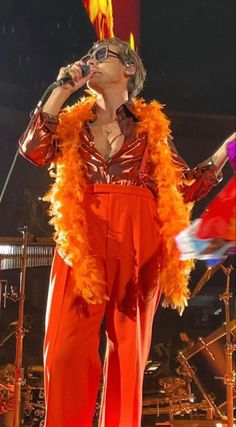 a woman in an orange outfit on stage