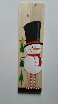 a snowman is painted on a wooden plank