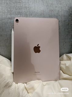 an apple ipad is sitting on a bed