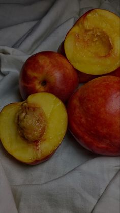 four pieces of fruit sitting on top of a white cloth