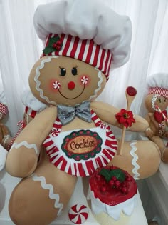 a large gingerbread man sitting on top of a table next to other stuffed animals