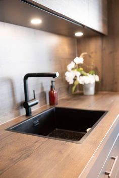 a kitchen sink sitting under a window next to a faucet and counter top