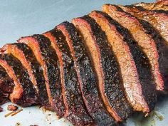 sliced steak on a plate with sauce and seasoning sprinkled on it's side