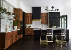 a large kitchen with wooden cabinets and black counter tops, along with bar stools