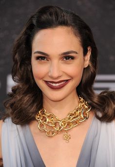 a woman wearing a necklace and smiling at the camera