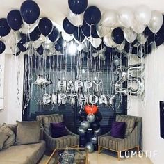 a living room filled with couches and balloons in the shape of happy 65th birthday