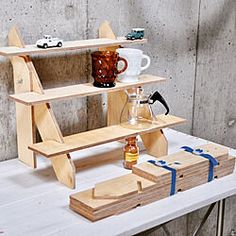 a wooden shelf sitting on top of a table next to a cup and other items