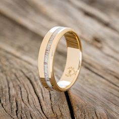 a wedding ring with two wood inlays on top of a piece of wood