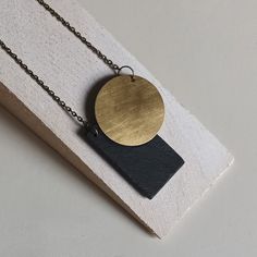 DUO collection with reversible double face pendant composed of the overlapping of the rectangle in slate and the round in brass; 3x2 mm chain in antique bronze color. It is a long necklace without closure, it can be worn by choosing the face you prefer. Two different pendants in one necklace! Entirely handcrafted, handmade in Italy. The slate, which comes from the waste processing of companies in the province of Genoa, is recovered, recycled and worked again. This type of work, totally handmade, Minimalist Brass Necklace With Rectangular Pendant, Handmade Minimalist Bronze Necklace, Minimalist Handmade Bronze Necklace, Minimalist Brass Necklace With Square Pendant, Design Sculpture, Face Pendant, Types Of Work, Genoa, Style Gift