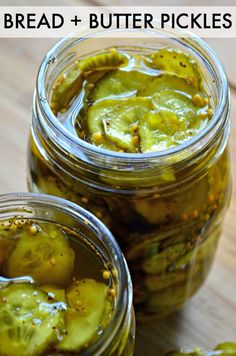 two jars filled with pickles on top of a wooden table