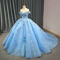 This Elegant Sky Blue Ball Gown is the epitome of grace and luxury, designed to make you feel like royalty on your special day. It is crafted from soft tulle fabric and boasts a voluminous ball gown silhouette, flowing beautifully into an exquisite cathedral train that adds drama and elegance with every step you take. The off-the-shoulder neckline enhances the gown's romantic charm, highlighting the shoulders and collarbones for a timeless and flattering effect. The sweetheart neckline creates a Princess Ball Gowns Blue, Princess Gown Royalty, Quince Stuff, Blue Sweet 16, Quinceanera Themes Dresses, Princess Evening Dress, Prom Dresses Off The Shoulder, Structured Corset, Quinceanera Dresses Blue