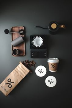 coffee and other items on a table with black background, including paper bag, scissors, measuring tape, spoons