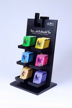 a display case with six different colored boxes on it's sides and the bottom shelf is black