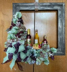 a wreath with wine bottles and grapes on it